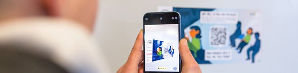 Mann mit Smartphone scannt einen QR-Code