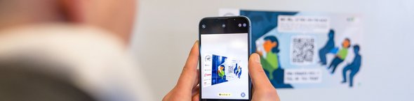 Mann mit Smartphone scannt einen QR-Code
