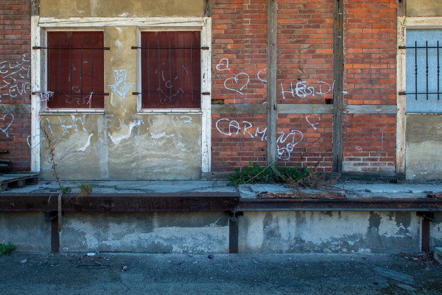 Verbarrikadierte Fenster und Graffiti am Gebäude
