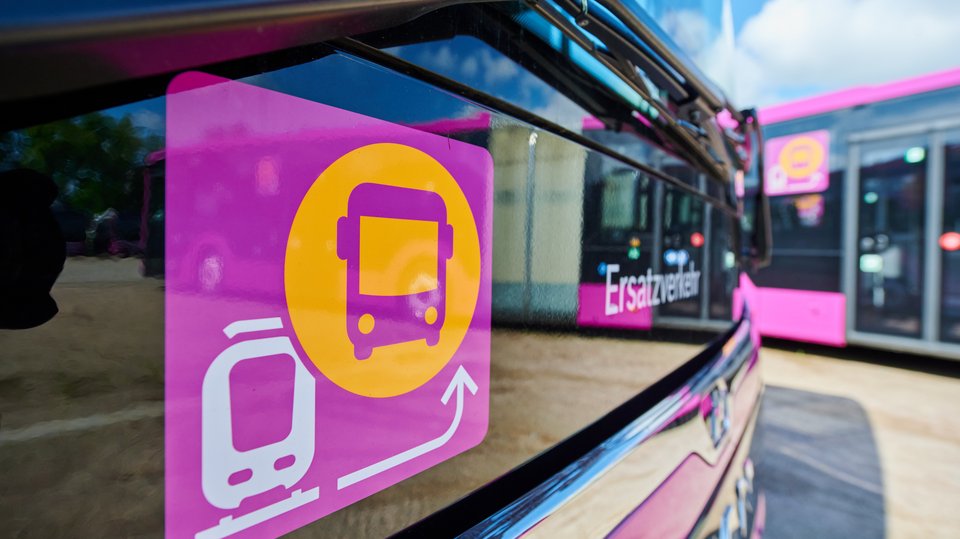 Das Foto zeigt das Piktogramm für den Ersatzverkehr in Nahaufnahme, im Hintergrund einen Bus