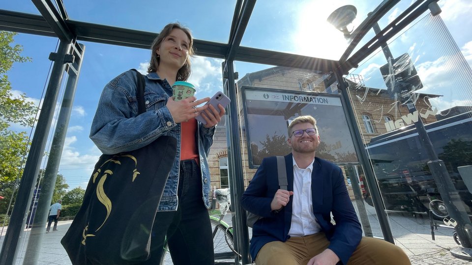 Zwei Personen warten an eine Bahnhof