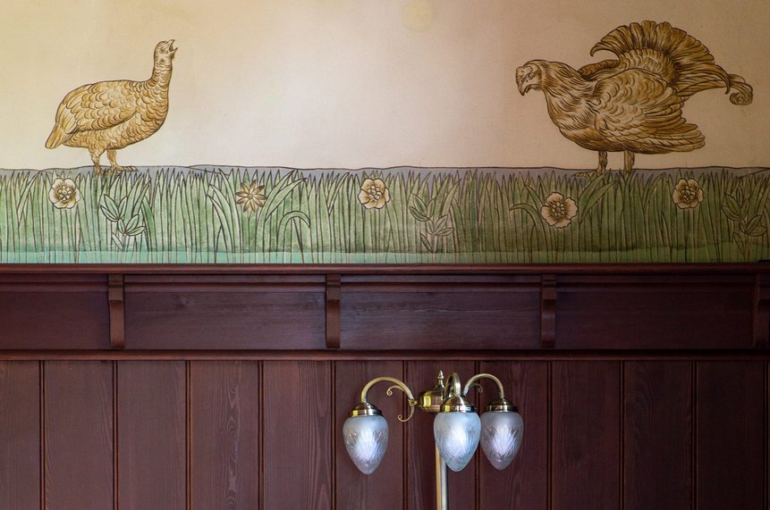 Ausschnitt der Wandvertäfelung mit dekorativer Bemalung darüber