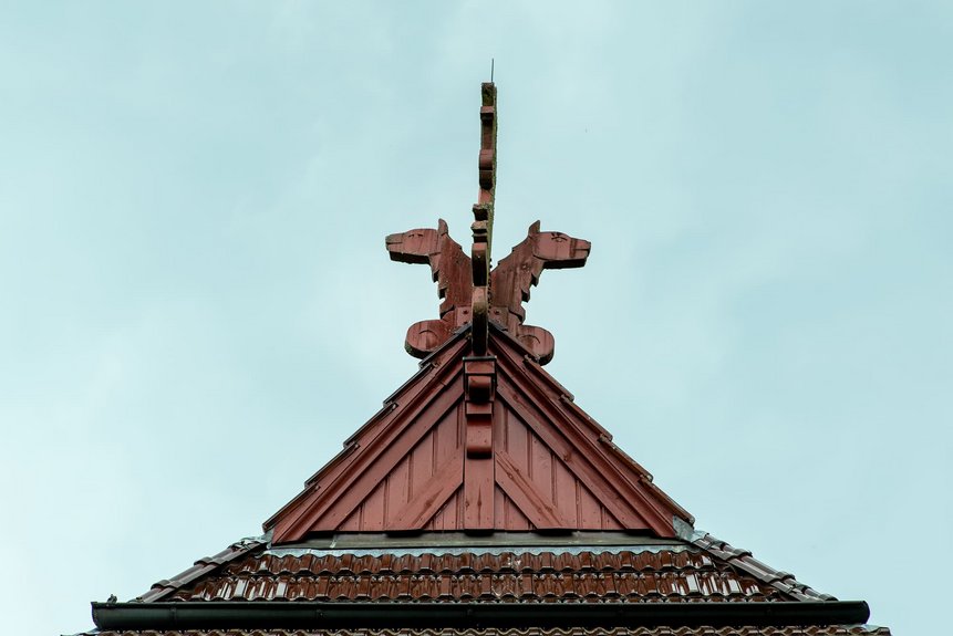 Ausschnitt des Spitzdachs mit Wappen aus Holz